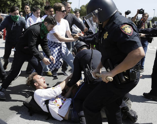 Police officers take a man into custody who was protesting Donald Trump outside the California GOP convention.
