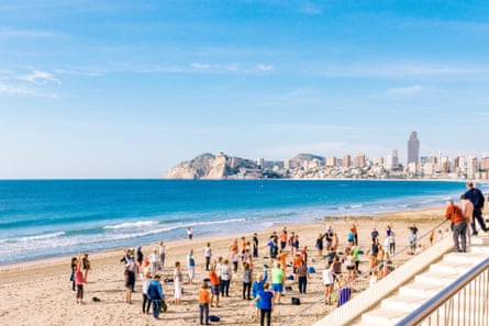 Older people exercise on the beach in Alicante, Spain.