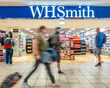 Travellers pass by a WH Smith retail outlet in departures
