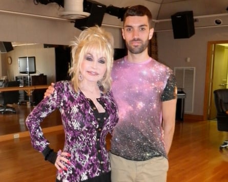 The journalist Joe Stone with Dolly Parton, both wearing purple sparkly tops