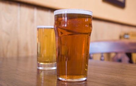 Une pinte et demie de bière sur une table de pub