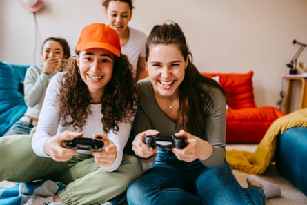 Young female friends enjoying video game at home