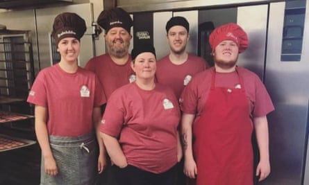 Sigurdur Enoksson with four members of his family in his bakery. They are wearing the bakery’s uniform and chefs’ hats