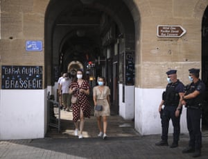 Riot police officers watch residents in Marseille. The French government is sending riot police to the region to help enforce mask requirements, as more and more French towns and neighbourhoods are imposing mask rules starting Monday to slow rising infections.