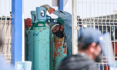 A worker offloads oxygen cylinders in Queretaro, Mexico, on 21 Jan 2021.
