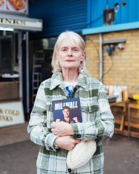 A woman outside The Den holding Millwall programme.