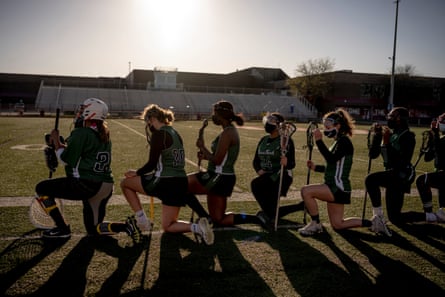 The Cass Technical High School Girl’s lacrosse team kneels for the National Anthem before the game against Chippewa Valley in Clinton Township, Michigan on April 30, 2021. Cass Tech took their second win of the season 14-6.