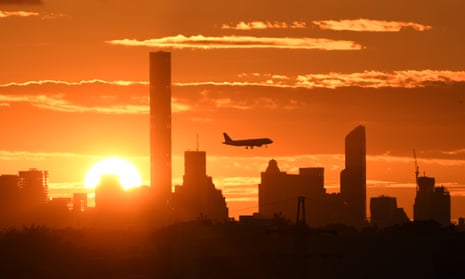 A plane flies over Manhattan as the sun sets in New York.