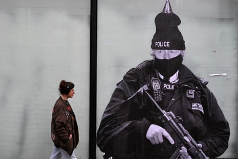 A pedestrian in Manchester passes an artwork by Foka Wolf, showing Boris Johnson dressed as a police officer wearing a party hat, in February this year.