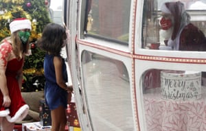 Rio de Janeiro, Brazil-A girl visits Santa Claus inside an old cable car at Urca Hill near Pao de Acucar Mountain (Sugar Loaf Mountain) during a Christmas event in Rio de Janeiro,