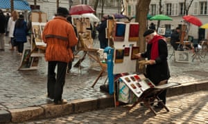 Atmospheric and colorful autumn street scene. Local artist setting up stall to sell paintings, with colorful umbrellas.