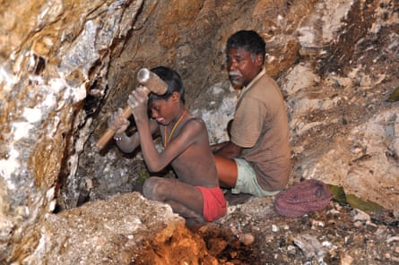 In this photograph from 2013, seven-year-old Karulal works with his father in a mica mine.