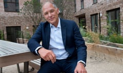 Marc Vlessing, chief executive of Pocket Living, sitting at an outdoors table next to a housing block