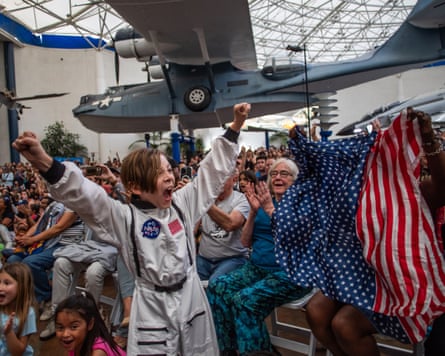 A young boy wearing an astronaut costume cheers during a watch party for the crew’s splash down in the Pacific Ocean.