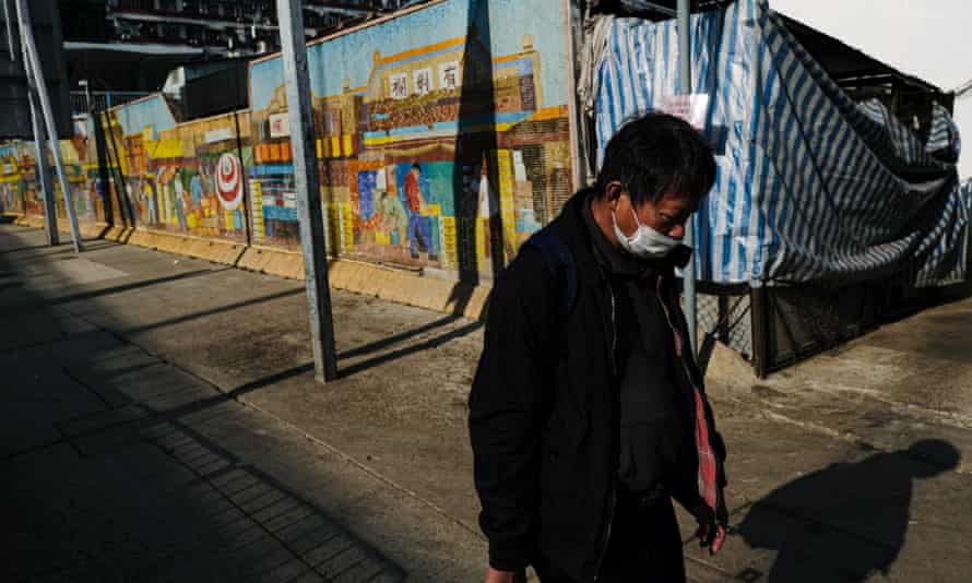 A man walks past a closed fruit market in Hong Kong