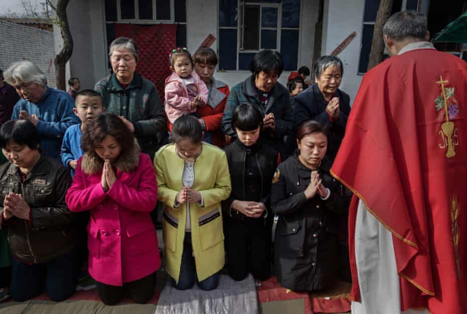 Os católicos esperam para comungar durante a missa do Domingo de Ramos em uma "igreja doméstica" perto de Shijiazhuang.