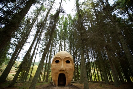 Sculpture of giant head and gaping mouth in forest