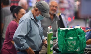 A man wears a face mask at a checkout in a Woolworths supermarket in Melbourne on Thursday as the supermarket allows the elderly and people with disabilities access to early morning shopping.