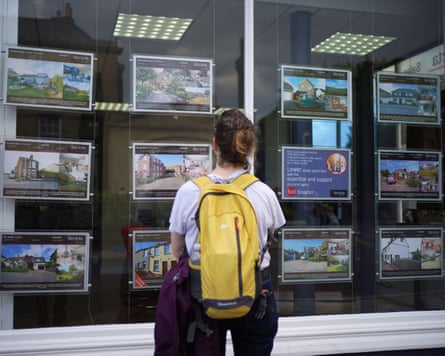 A woman looking at advertisements in an estate agent’s window