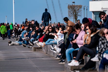 People sit in the sun at the western harbour in Malmo, Sweden, on 5 April.