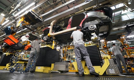People working on a car on a production line in a factory