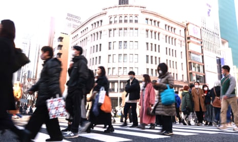 People cross a street at Ginza fashion district in Tokyo