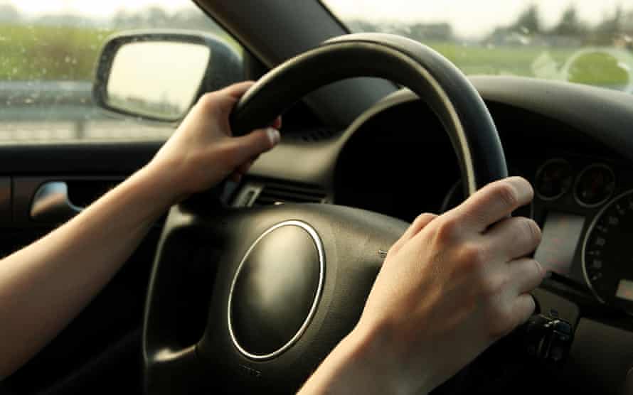 Quelqu'un avec les mains sur le volant d'une voiture