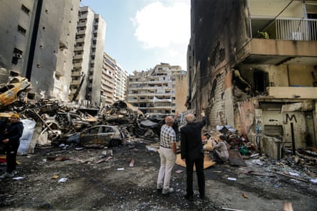 Lebanese civilians gesture as they inspect destruction caused by a massive Israeli air strike in Beirut, 08 April