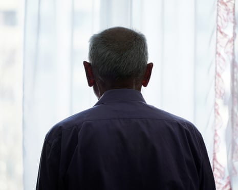 Silhouette of man looking through window with transparent curtain