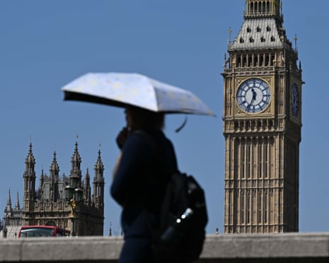 A silhouetted figure holding an umbrella stands near Big Ben and the Houses of Parliament