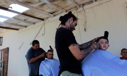 People cut hair in an improvised outdoor barber shop after a business was damaged by the passing of Hurricane Maria in Toa Baja, Puerto Rico.