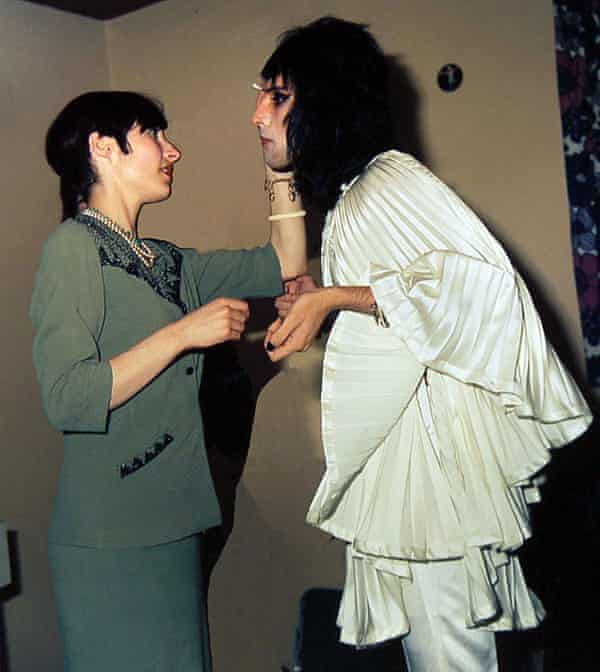 Freddie Mercury wearing a Zandra Rhodes creation with a makeup artist before going on stage at a London concert in 1974.