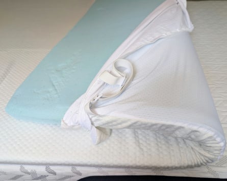 The zipped cover of the Panda Bamboo mattress topper unzipped to reveal the memory foam inside.