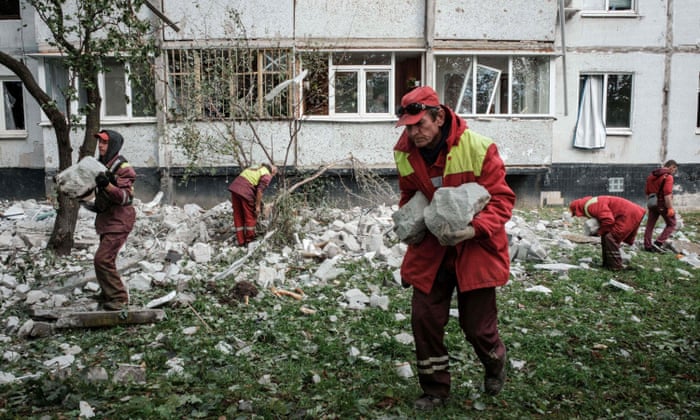 Municipal workers remove the debris from the top of a residential building hit by a missile attack in Kharkiv.
