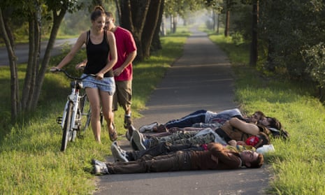 Local cyclists pass a group of Afghan men who crossed from nearby Serbia sleeping on a bicycle path in Morahalom, Hungary.