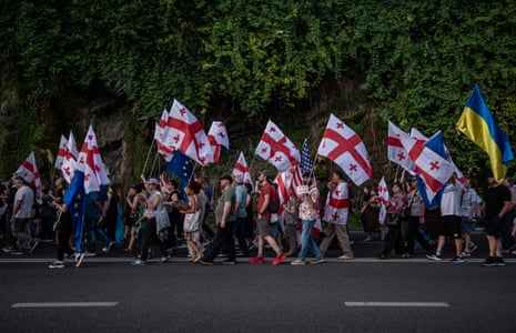 Demonstrators in Tbilisi march waving Georgian, EU and Ukrainian flags together