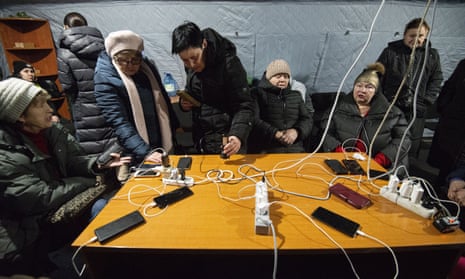 Kyiv residents charge their mobile phones at one of the country’s ‘points of invincibility’ providing power, water and food