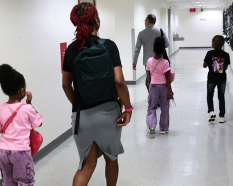 Families walk down a hallway in a courthouse