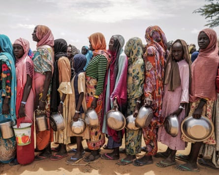 Sudanese women who fled the conflict in the Darfur region line up to receive Red Cross food aid on the outskirts of Adre, Chad.