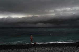 Nice, France. Two beach-goers look at the clouds before a storm along the Promenade des Anglais on the french riviera