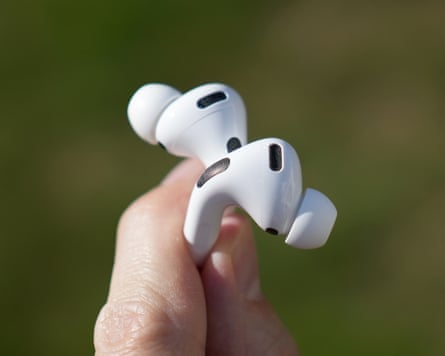 A pair of AirPods Pro 3 earbuds held between fingers showing their tips and vents