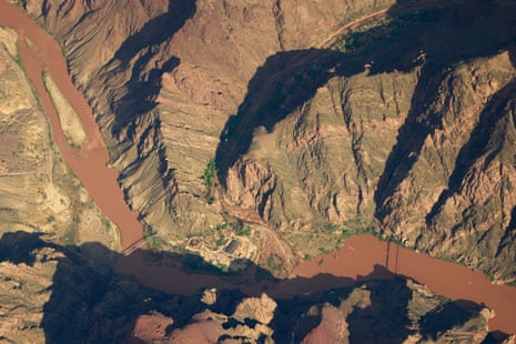 aerial view of brown, muddy river flowing through canyon