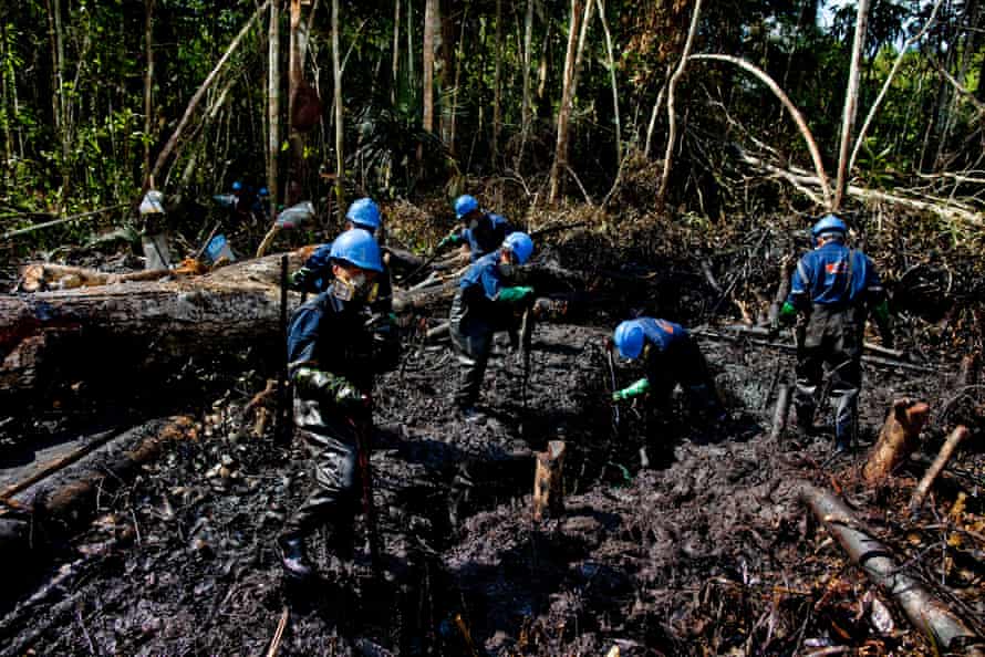 Workers from Argentine firm Pluspetrol clean up after an oil spill in the Amazon region of Loreto, 10 August 2011, after about 1,100 barrels of oil were leaked into the jungle
