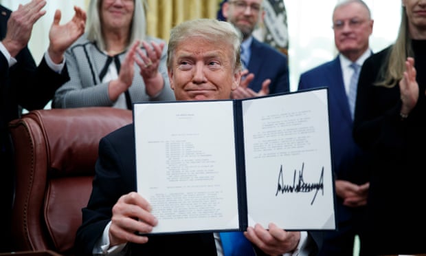 Donald Trump participates in a signing ceremony for the directive.