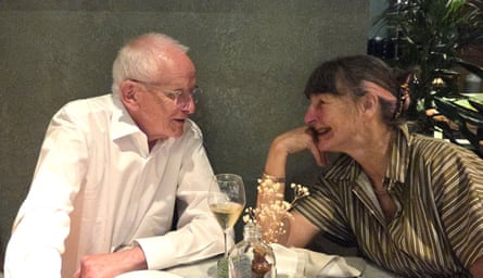 Philip and Carol sitting at a table looking warmly at each other on their date.