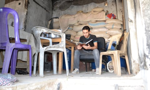 An anti-Assad fighter reading on the frontline