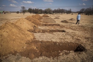 A worker walks past freshly-dug graves at the Honingnestkrans cemetery, north of Pretoria, South Africa.