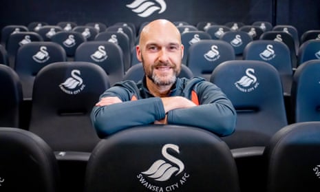 Luke Williams poses for a picture after signing a contract to become manager of Swansea City