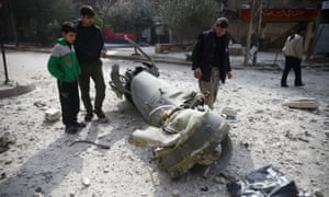 Menschen untersuchen die Überreste einer Rakete in der Stadt Douma im Osten von Ghouta, Syrien