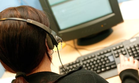 A woman in a telephone headset at a call centre.